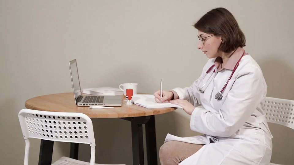 Una dottoressa prende appunti nello studio medico. Scena stock illustrativa.